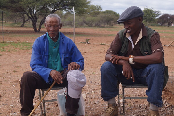 Two men sitting and smiling for a photgraph