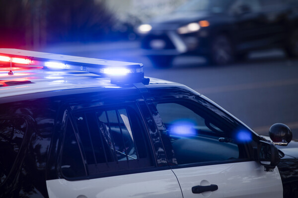 A police car with its lights on the roof.