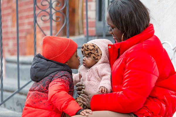 talicia sitting on her door step with children