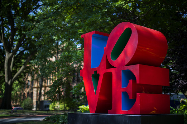 dramatic light on Robert Indiana’s LOVE statue on Penn’s caption.