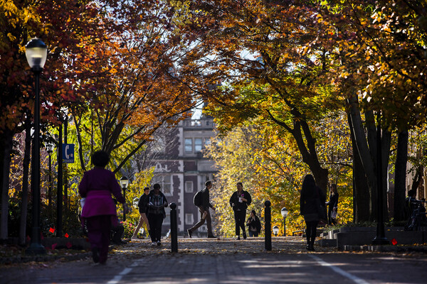 People walking along Locust Walk in autumn.