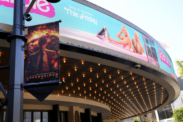Barbie and Oppenheimer advertisements on a theater. 