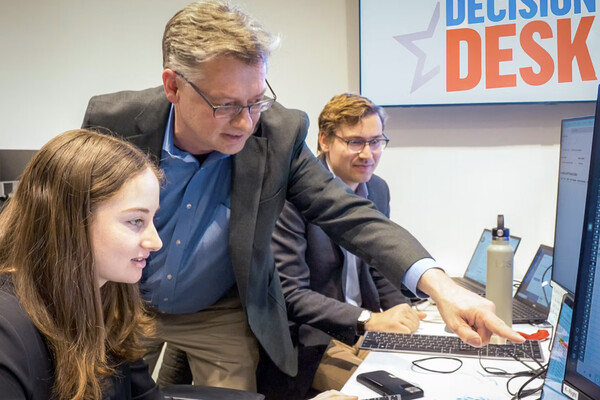 John Lapinski and PORES students at a computer at the Decision Desk.