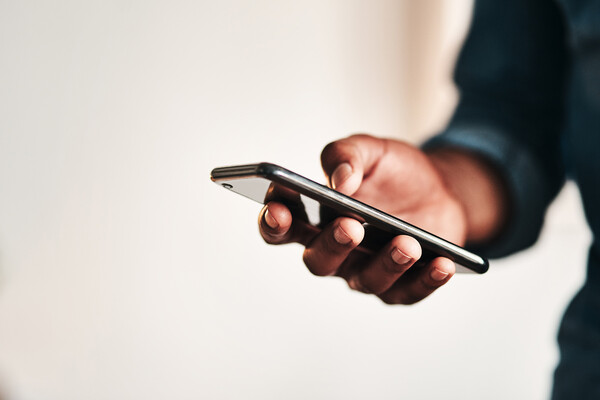 A person’s hand holding  a smartphone.