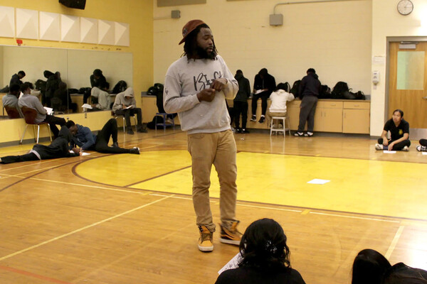 Donnell Powell in a gymnasium with young students.