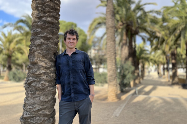 Marc Marin Webb poses next to tree.