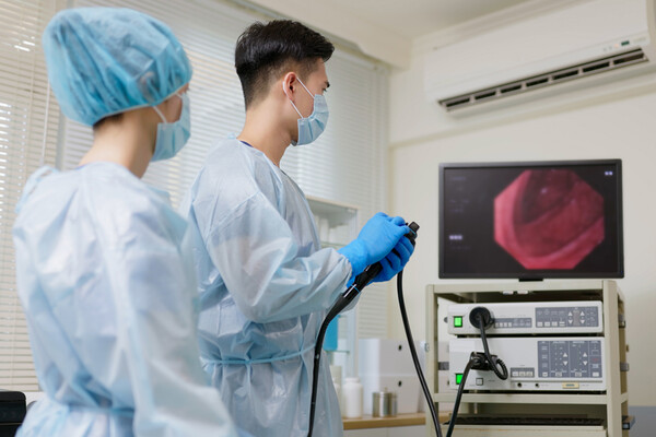 Two medical professional looking at a screen during a colonoscopy.