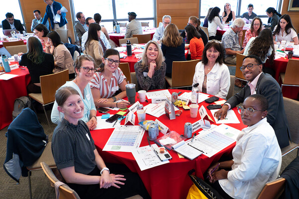 A large group of people seated at tables at a conference.