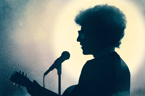 Bod Dylan in profile at a microphone.
