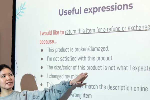 A person at a projector screen teaching English.