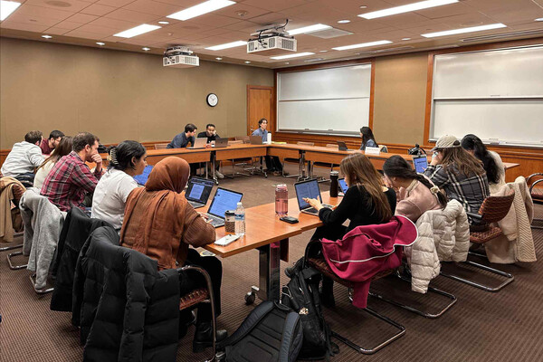 Students in the Entrepreneurship Legal Clinic in a classroom working on laptops.