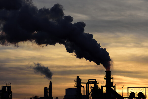 A factory chimney spilling smoke into the sky.