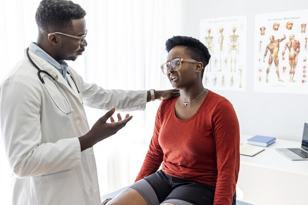 A doctor speaks to a patient in a doctor's office.
