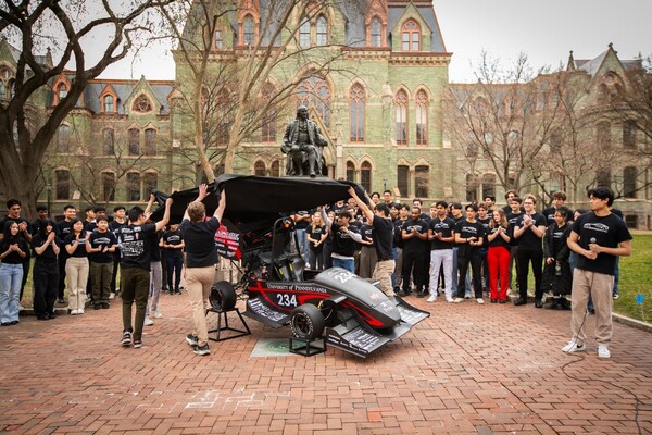 Students unveil their latest self-made electric race car on College Green, just in front of Benjamin Franklin statue.