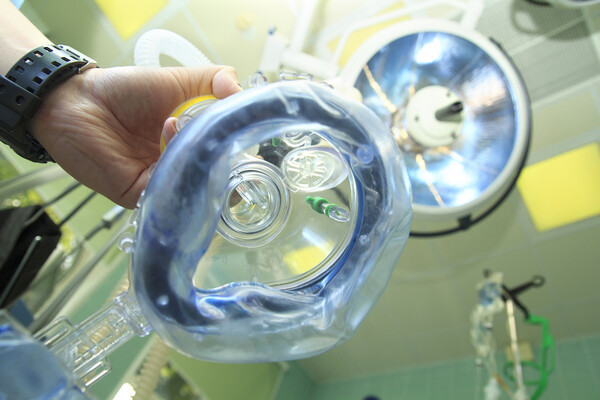A laughing gas mask hovering over a patient’s perspective.