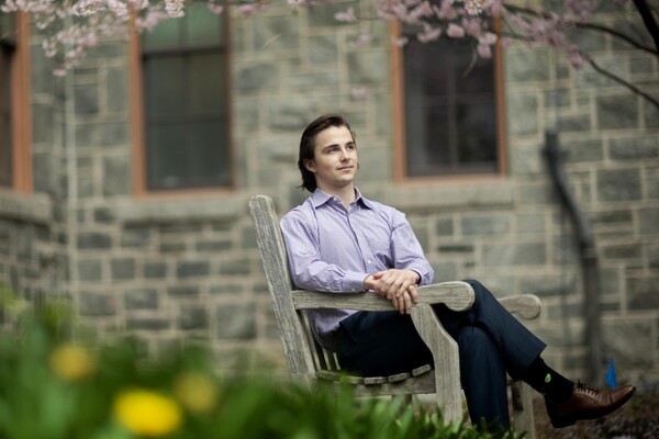 William Reason sitting on a bench outside. 