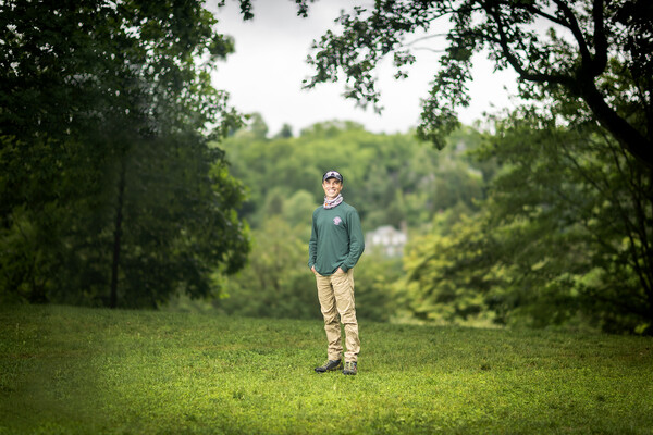 Peter Fixler stands among the trees and greens at the Morris Arboretu.
