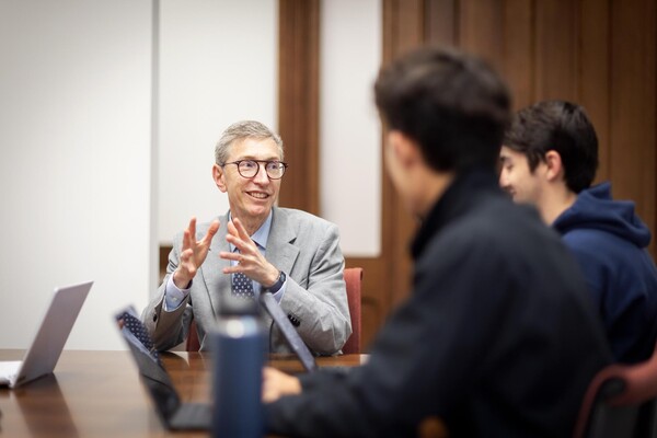 Russell Composto at a conference table gesticulating with undergraduates.