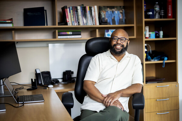 Desmond Patton seated at his desk.