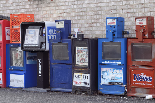 A row of newspaper boxes, mostly empty.
