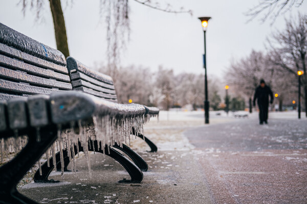 An icy bench in a city.