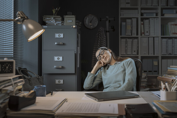 A person sleeping at their desk.