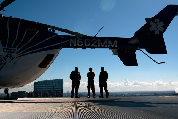 Three members of the PennSTAR flight crew next to a helicopter.