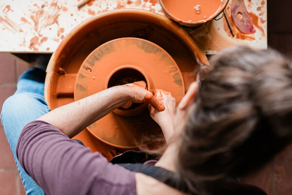 Alex Watrous throwing pottery on a wheel.
