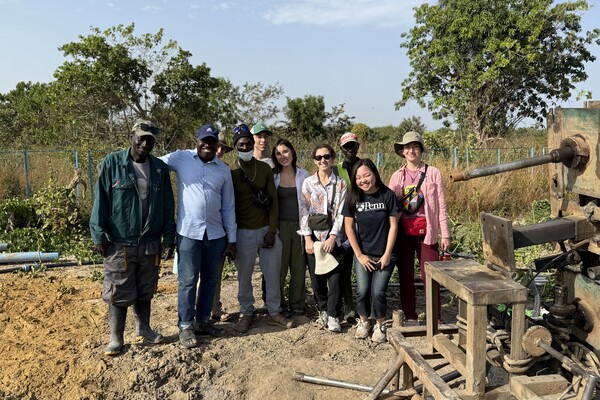 A group photo in front of a borehole drilling machine at Alna Farms in Gambia.