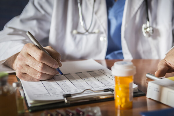 A doctor writing out a prescription.