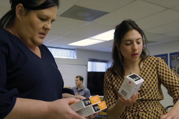 Two people unpacking boxes of Narcan in a rural community.
