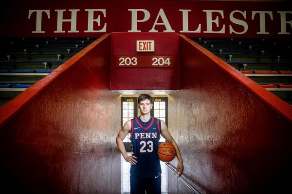Ethan Roberts holding a basketball at the entrance to the Palestra.