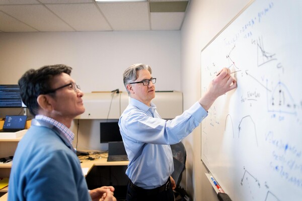 Kent Smetters and another person looking at a whiteboard