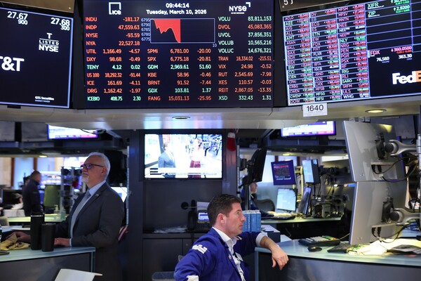 Traders at the New York Stock Exchange looking at monitors.