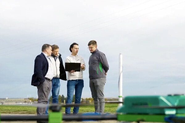 Four members of the Nirby team on a farm looking at a laptop.