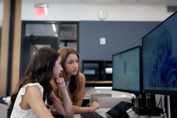 The two members of Sync Labs working on a desktop computer.