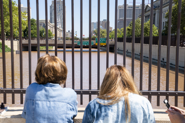 Two people looking at the flooded highway overpass in Philadelphia after flooding from Hurricane Ida.