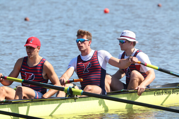 Cole Reidinger (center) rowing with two teammates.