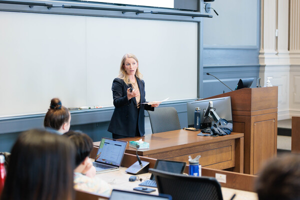Sarah Pierce behind a desk teaching a class.