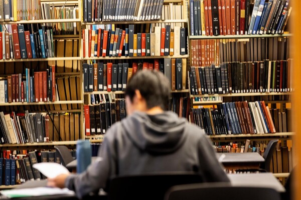 A student studying in book stacks during Reading Days.