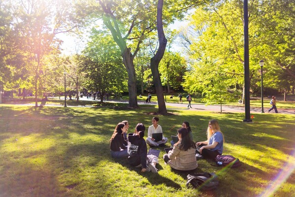Penn students sitting on College Green in front of College Hall.