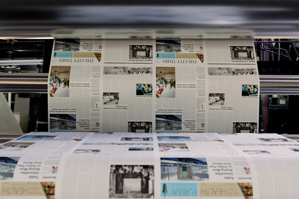 A newspaper being printed on a modern printing press. 