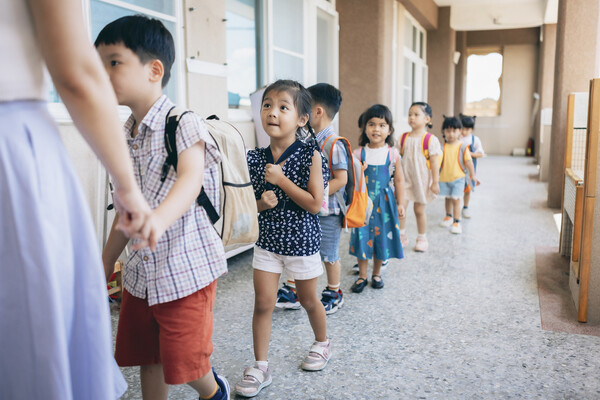 Schoolchildren lining up to go into a classroom.