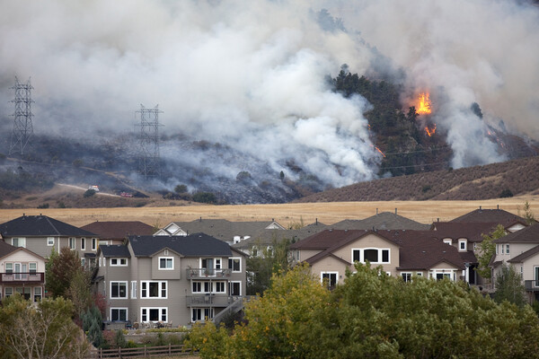 A Colorado wild fire burns behind homes.