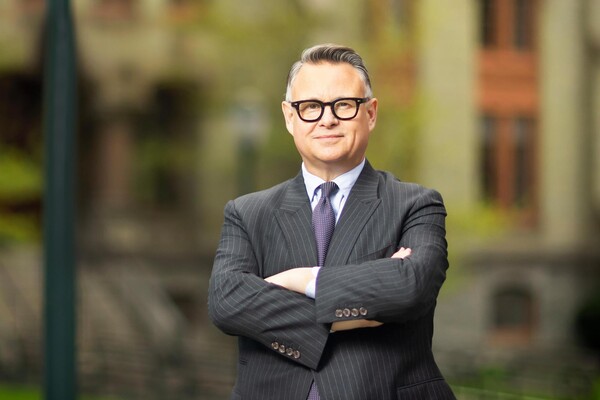 Mark Trodden with folded arms in front of College Hall.