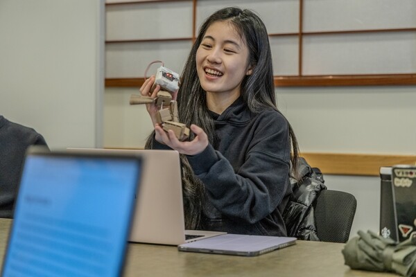 A student experimenting with a handheld STEM project in a classroom.