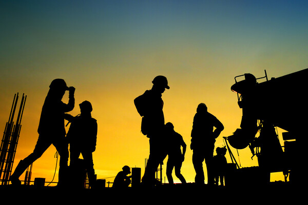 A group of construction workers work in the hot sun.