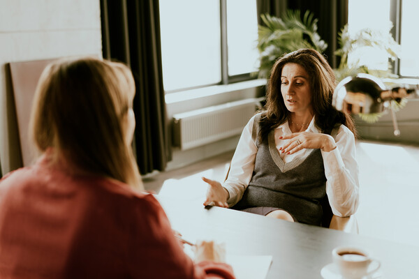 Two people seated at a desk mid-negotiation.
