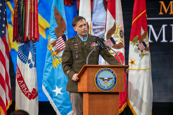 Nick Dockery speaking at a podium in decorated uniform.