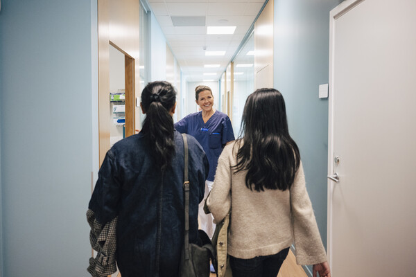 A nurse greeting two patients.
